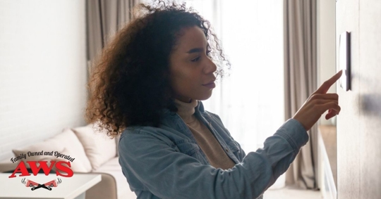 Woman adjusting thermostat